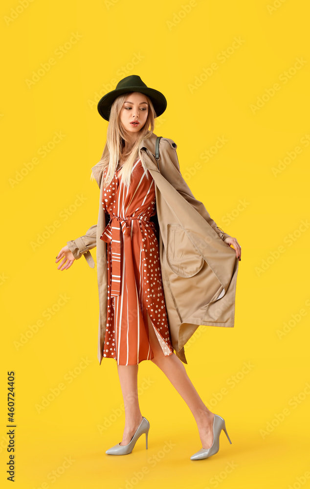 时尚女士，穿着时尚的鞋子，黄色背景毡帽