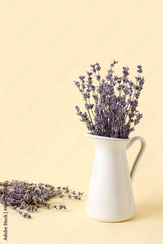 Jug with beautiful lavender flowers on color background
