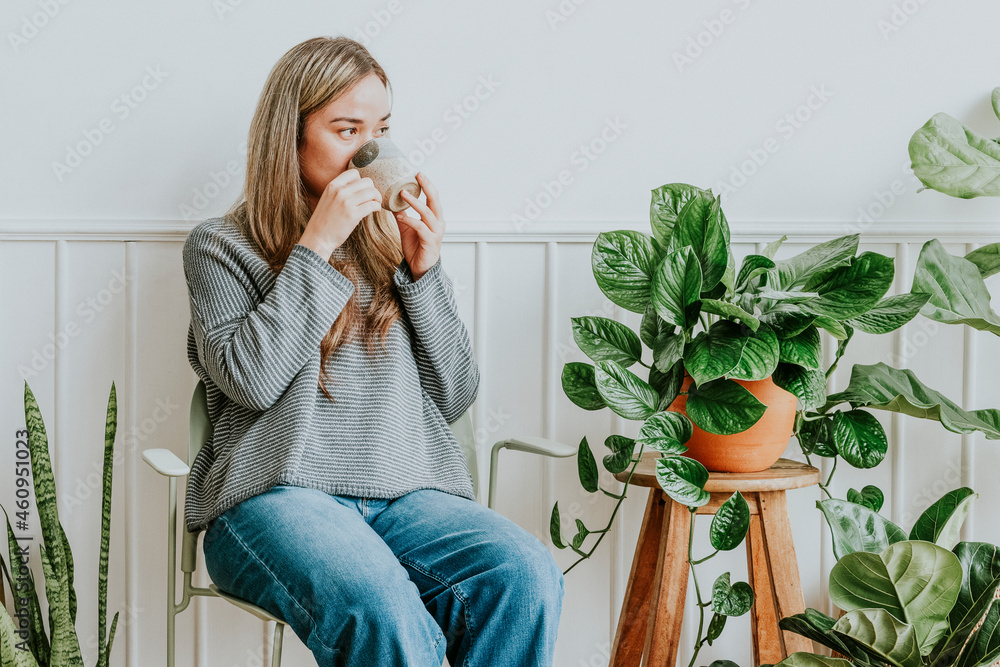 植物女士在她的植物角落休息喝茶