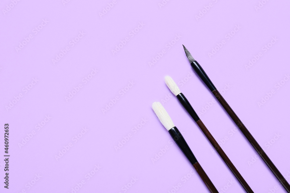 Calligraphic brushes on lilac background
