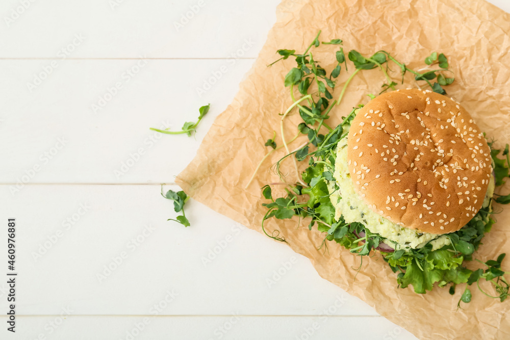 Tasty vegetarian burger on white wooden background