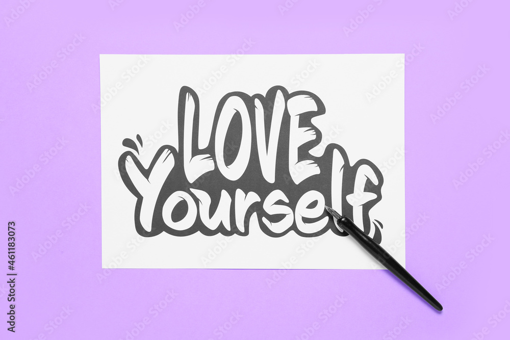 淡紫色背景上写着LOVE YOURSELF和笔尖的纸