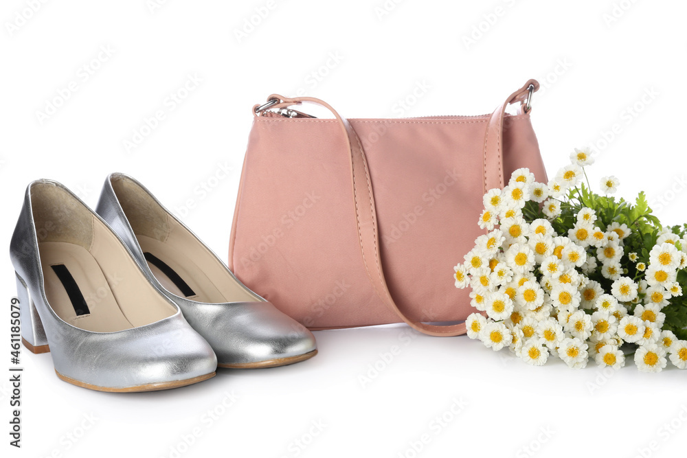 时尚的手提包、鞋子和白色背景的美丽花朵