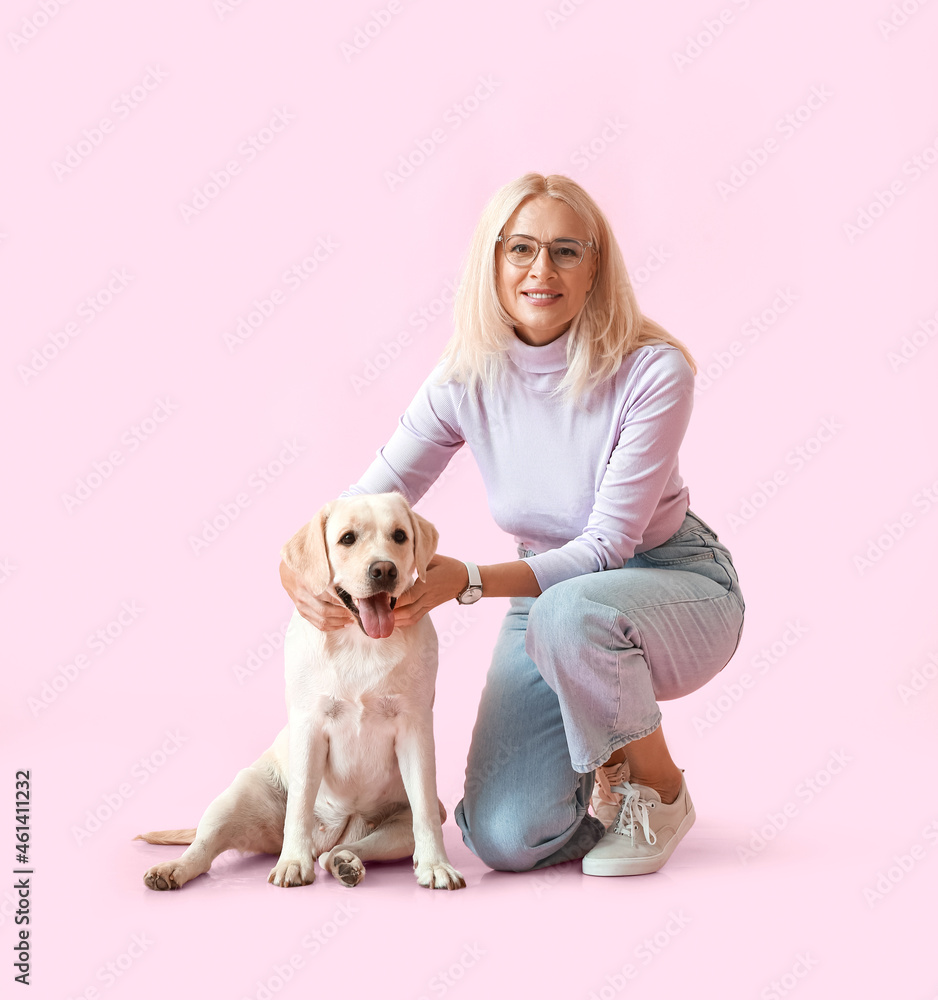 粉红色背景上有可爱拉布拉多犬的成熟女人