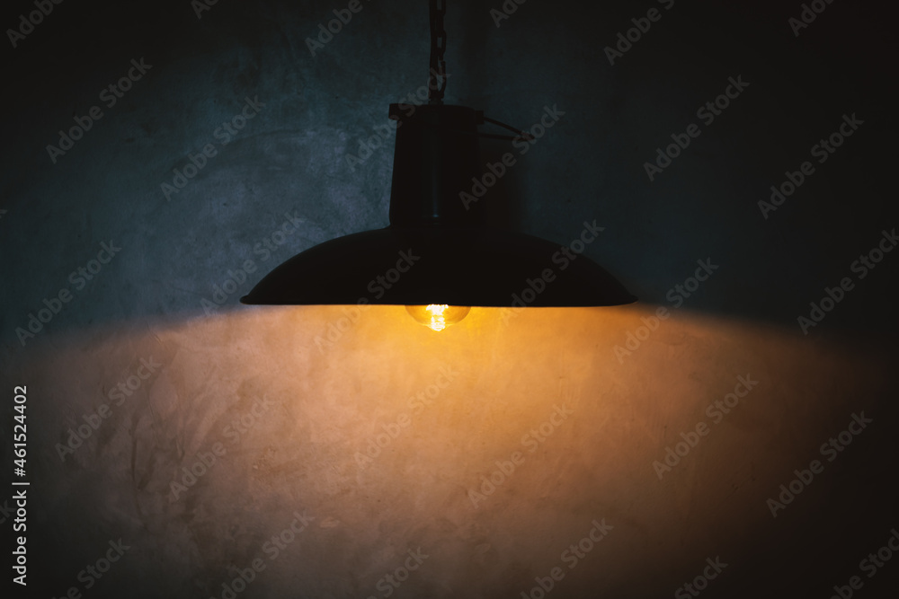 Black lamp and yellow light reflection on concrete wall