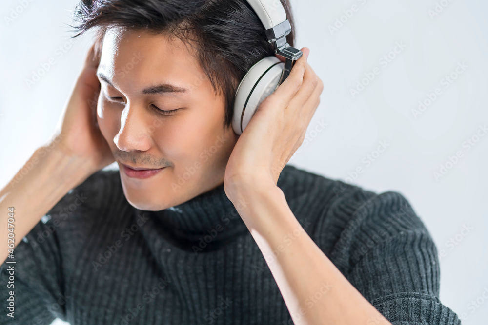 肖像工作室音乐抒情概念年轻聪明的亚洲艺术家戴毛衣听耳机享受mu