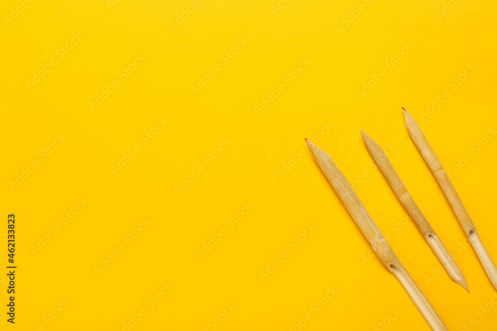 Wooden dip pens on yellow background