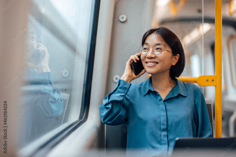 一位微笑的亚洲女商人在公共交通工具上的肖像。