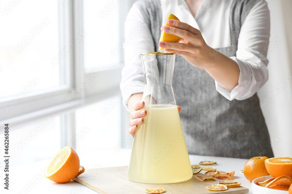 女人在厨房餐桌上制作新鲜柑橘汁
