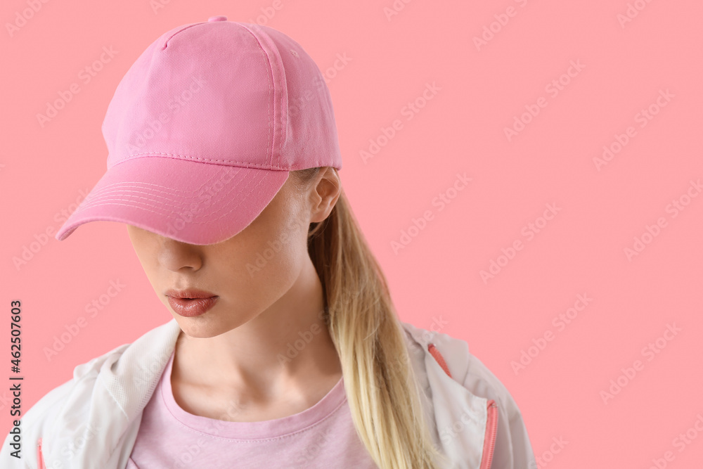 粉色背景戴棒球帽的女人，特写