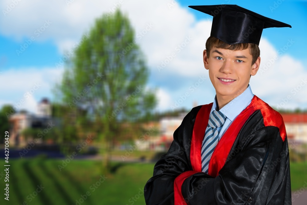 Portrait of handsome male graduate in a graduation robe