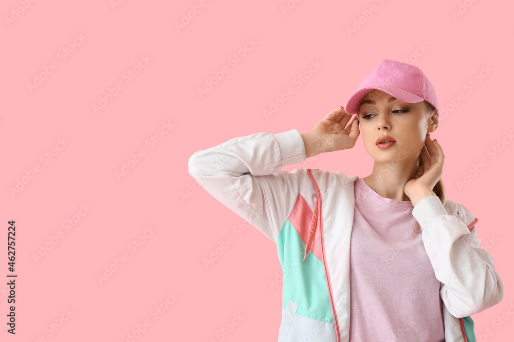 女人触摸粉色背景的棒球帽
