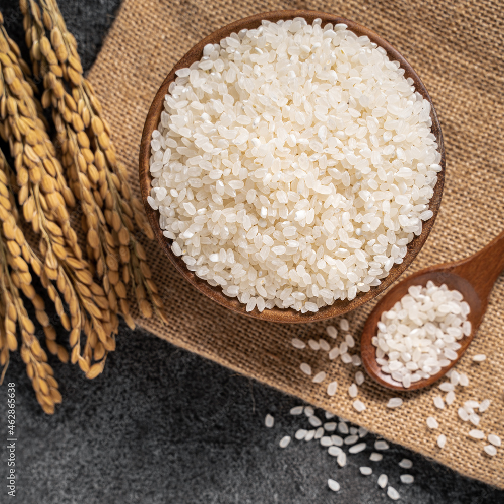White rice in a bowl on dark black table background.