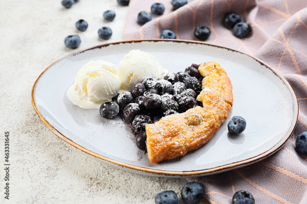 盘子里有美味的蓝莓奶油和冰淇淋，背景为浅色，特写