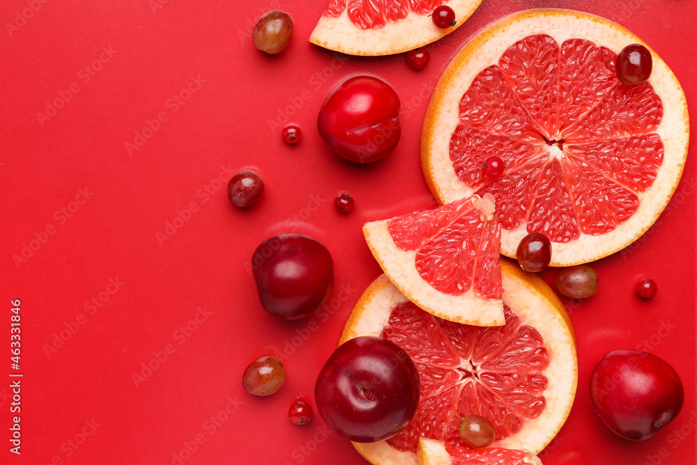 彩色背景的成熟葡萄柚、李子和葡萄片