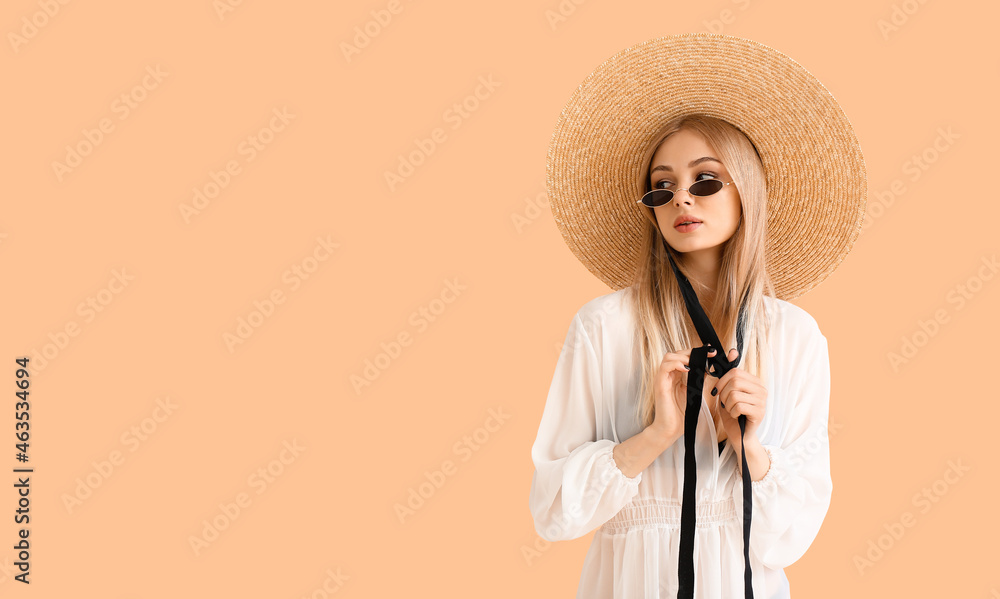 身穿沙滩裙，头戴彩色背景柳条帽的年轻女子