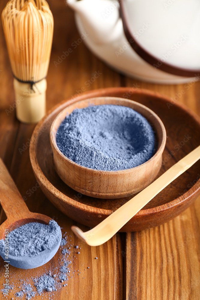 一碗木制背景的蓝色抹茶粉