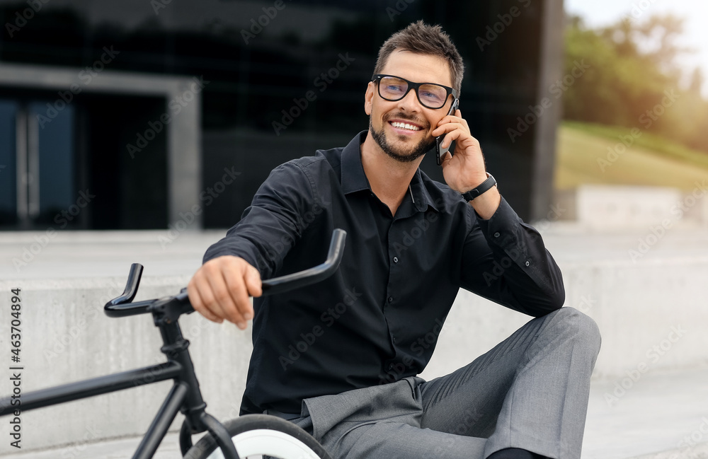 骑自行车的商人在城市街道上用手机交谈