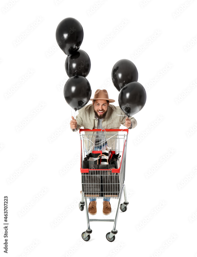 黑色星期五购物车里有购物袋，白底有气球的英俊男子