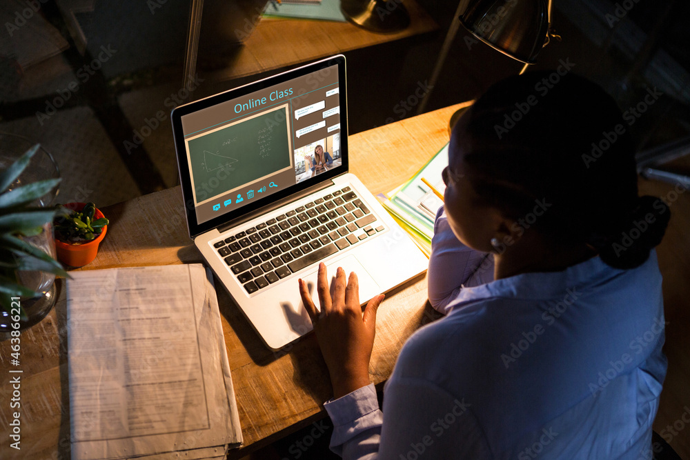 非裔美国女性使用笔记本电脑进行视频通话，屏幕上有微笑的白人女教师
