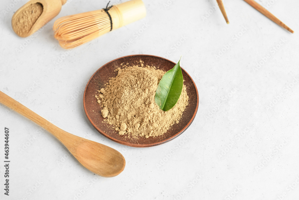 Plate with hojicha powder and spoon on white background
