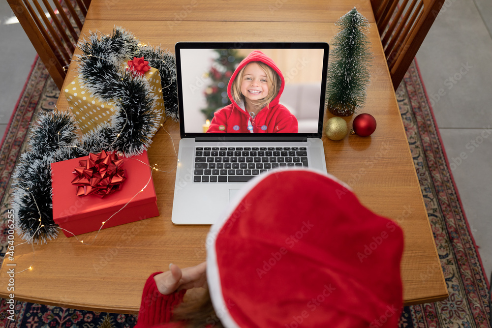 戴圣诞帽的白人妇女在圣诞笔记本电脑上与白人女孩视频通话