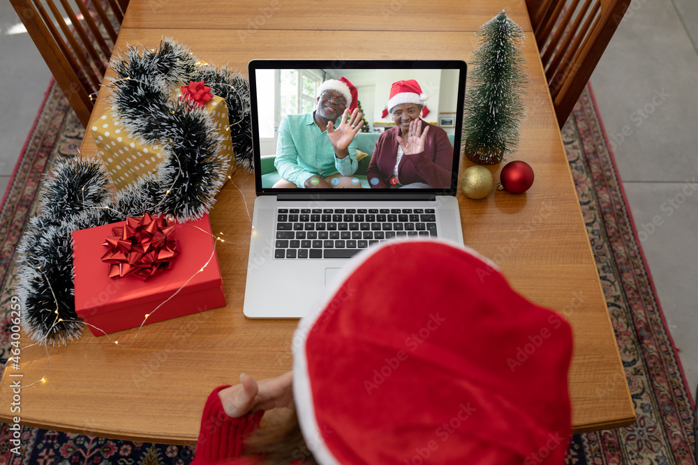 Caucasian woman in santa hat on christmas laptop video call with friends