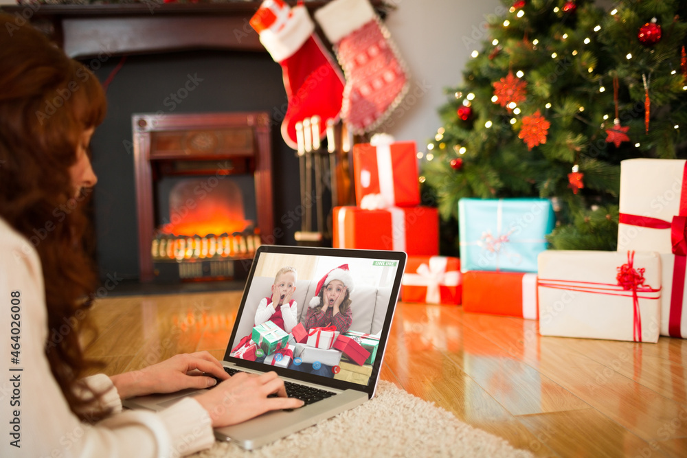 高加索女子与两个兴奋的高加索兄弟姐妹进行圣诞笔记本电脑视频通话
