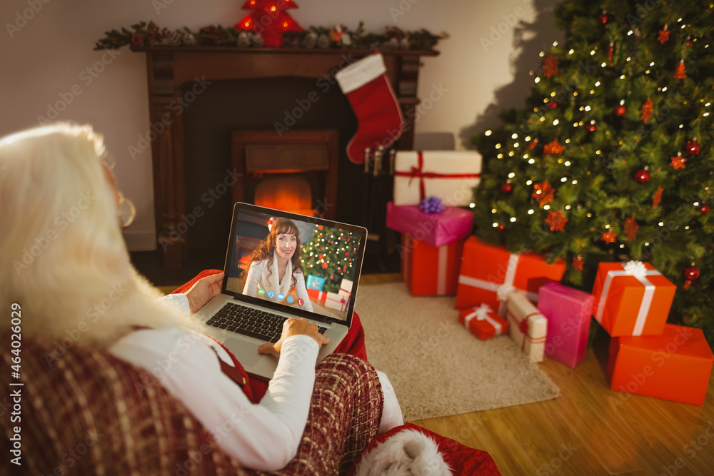 圣诞老人与微笑的高加索妇女进行圣诞笔记本电脑视频通话