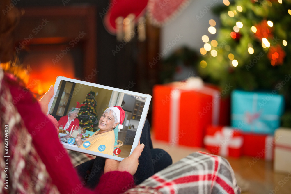 高加索妇女与微笑的年长母亲和祖母进行圣诞平板电脑视频通话