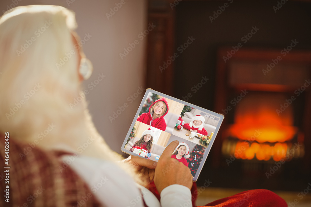 圣诞老人与四个微笑的高加索女孩进行平板圣诞视频通话