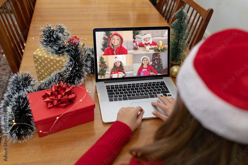 高加索女子与四个微笑的女孩进行笔记本电脑圣诞视频通话