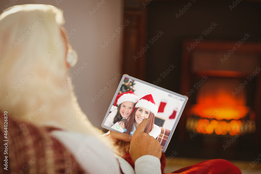 圣诞老人与微笑的高加索母女进行平板电脑圣诞视频通话