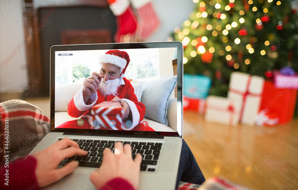 高加索女人在圣诞笔记本电脑上与高加索圣诞老人视频通话