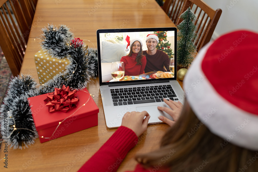 圣诞笔记本电脑上的高加索女子与高加索夫妇视频通话