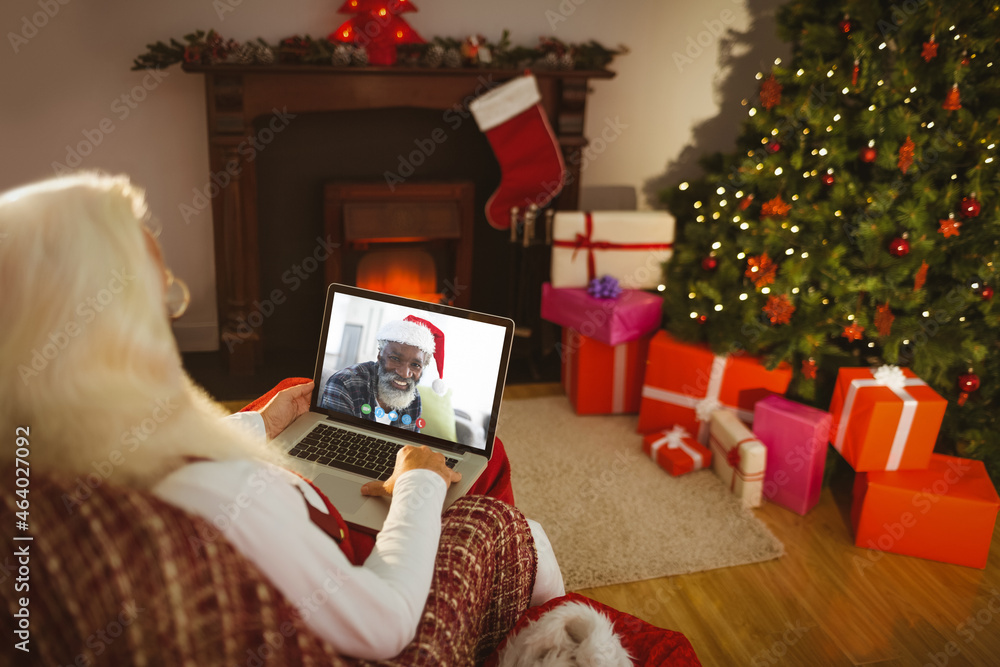 高加索圣诞老人在圣诞笔记本电脑上与非裔美国人视频通话