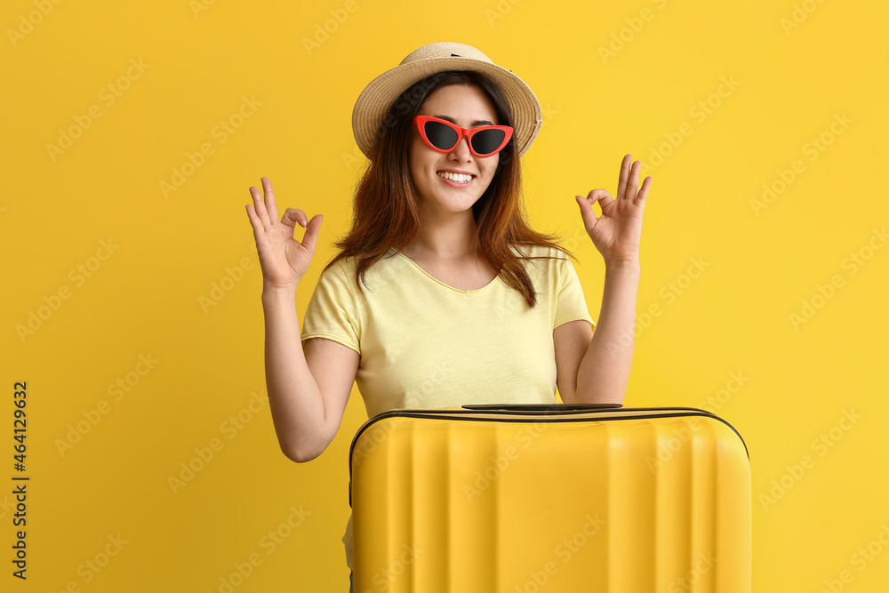 年轻女子提着行李箱，颜色背景显示OK