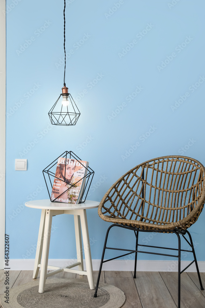 蓝色墙壁附近带杂志的现代桌椅