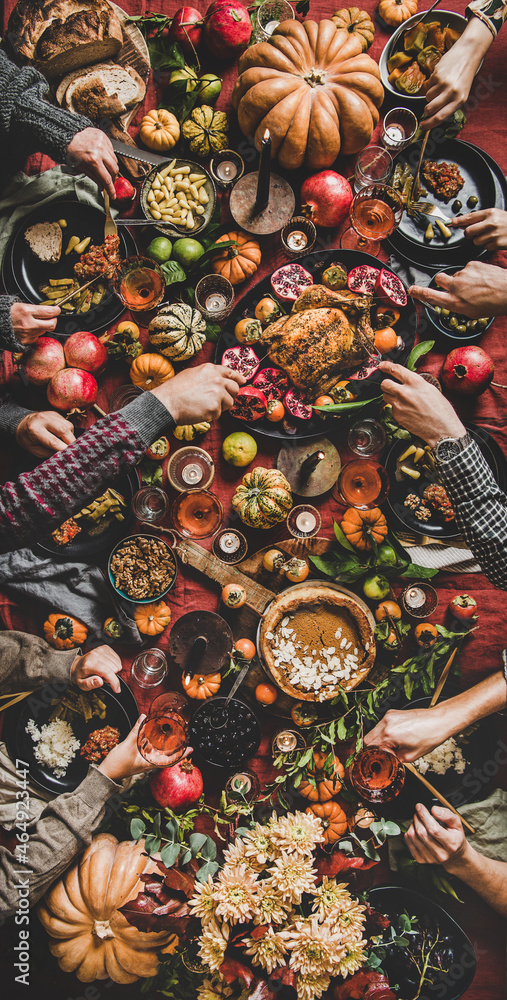 People eating and drinking wine at Thanksgiving table, vertical composition