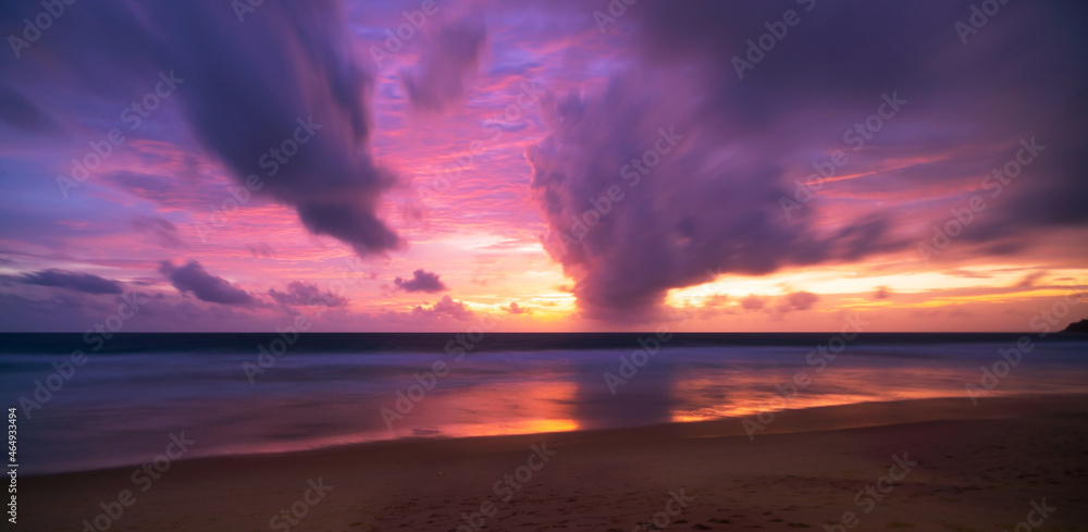 美丽的运动模糊了长时间曝光的日落或日出，在平静的海面上形成了戏剧性的天空云