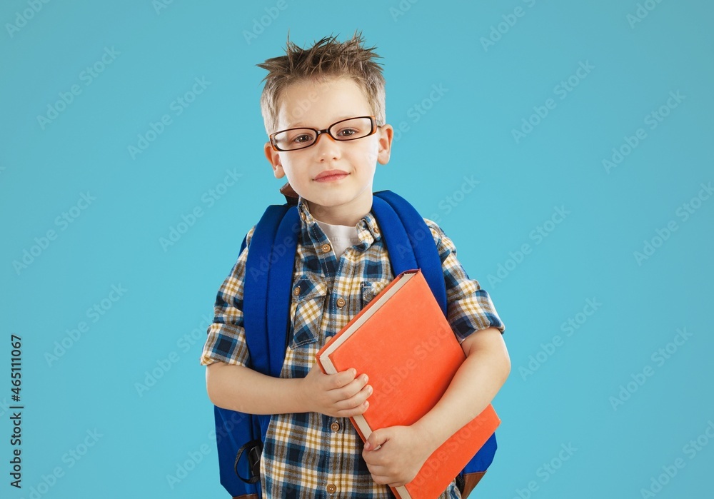 Smiling little kid with backpack hold books