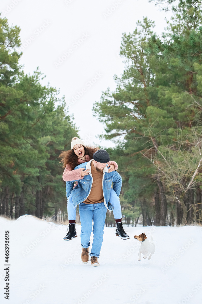 快乐的年轻夫妇在冬日的森林里玩得很开心