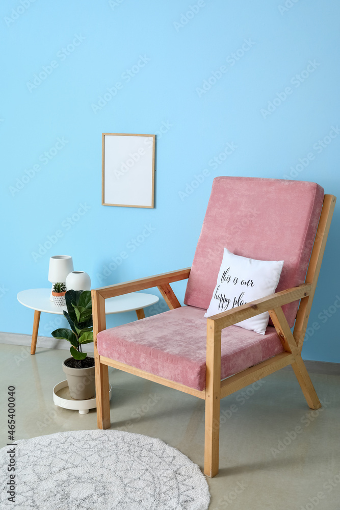 带装饰的房间里靠近彩色墙的时尚扶手椅