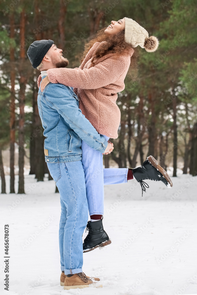 快乐的年轻情侣冬日在森林里玩得很开心