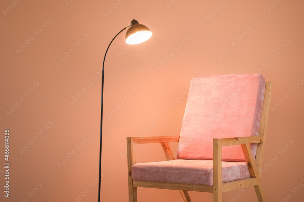 彩色墙背景附近的木制扶手椅和灯具