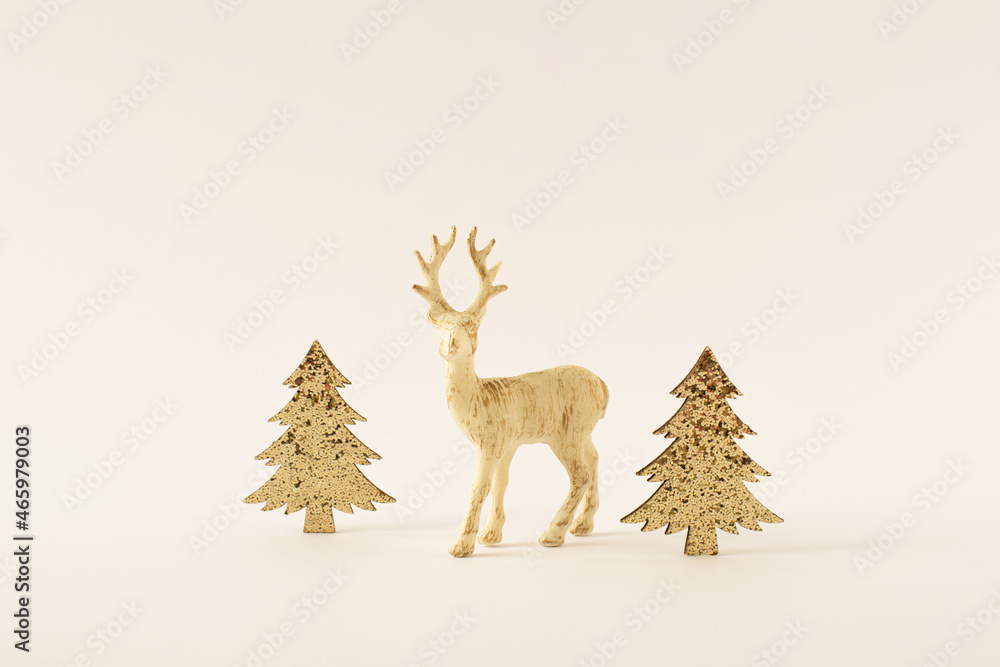 白色圣诞节的极简主义创意，由闪闪发光的金色树木和驯鹿制成