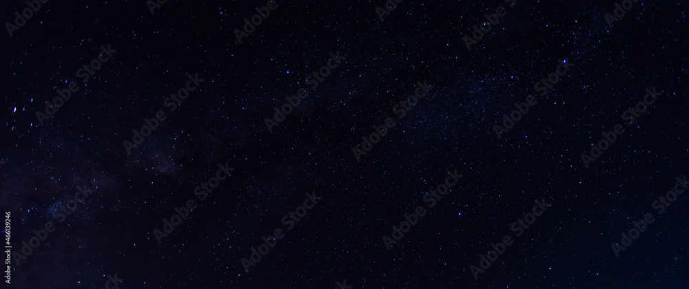 银河系的蓝色夜空和黑暗背景下的恒星全景。宇宙充满了恒星、星云和