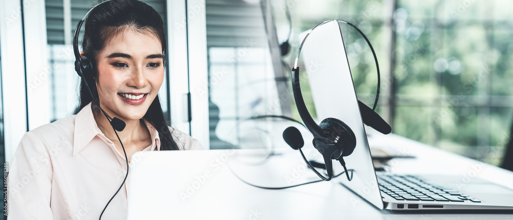 Businesswoman wearing headset working actively in office . Call center, telemarketing, customer supp
