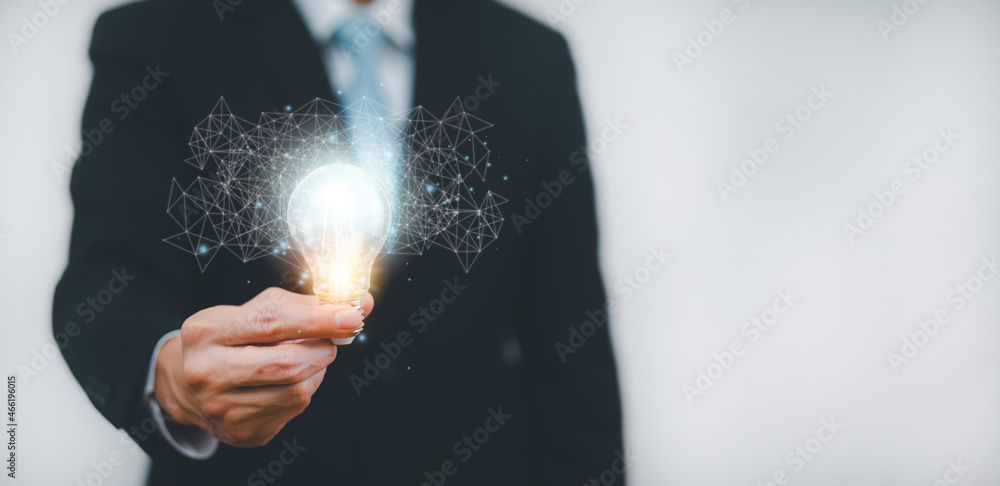 带线路连接的商务手持灯泡和在办公桌上工作的双重曝光，Creativit
