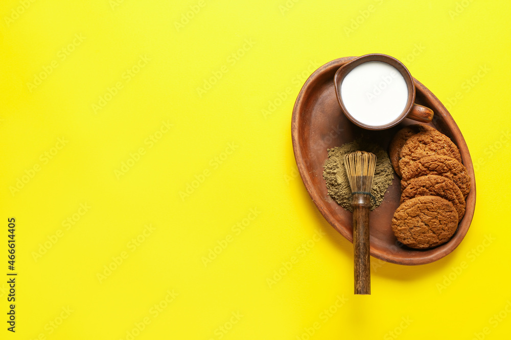 盘子里有美味的hojicha饼干、一罐牛奶和黄色背景的追逐